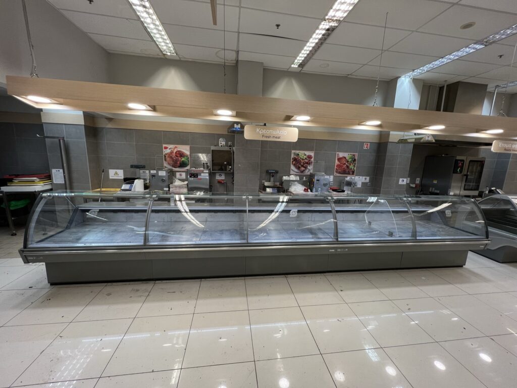 Ψυκτικές βιτρίνες κρεοπωλείου εγκατεστημένες σε σούπερ μάρκετ από εξειδικευμένη ψυκτική εταιρεία, έτοιμες για τοποθέτηση νωπών προϊόντων κρέατος.