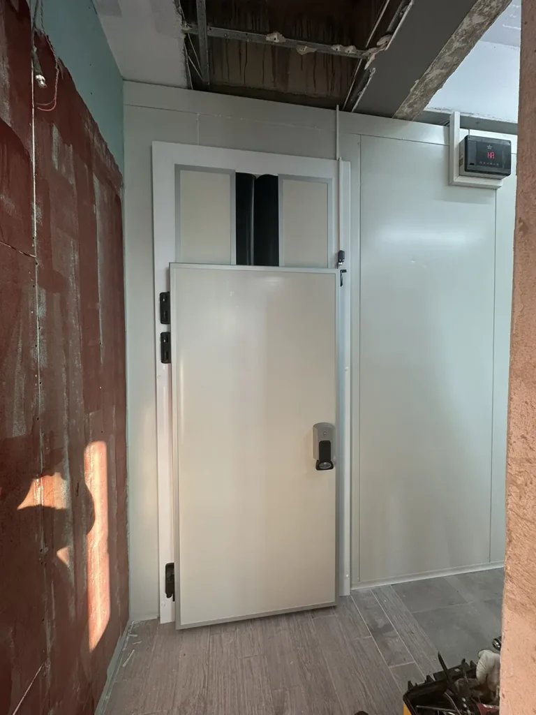 Πόρτα βιομηχανικού ψυκτικού θαλάμου εγκατεστημένη σε επαγγελματικό χώρο από εξειδικευμένη ψυκτική εταιρεία, με σύστημα ελέγχου θερμοκρασίας.